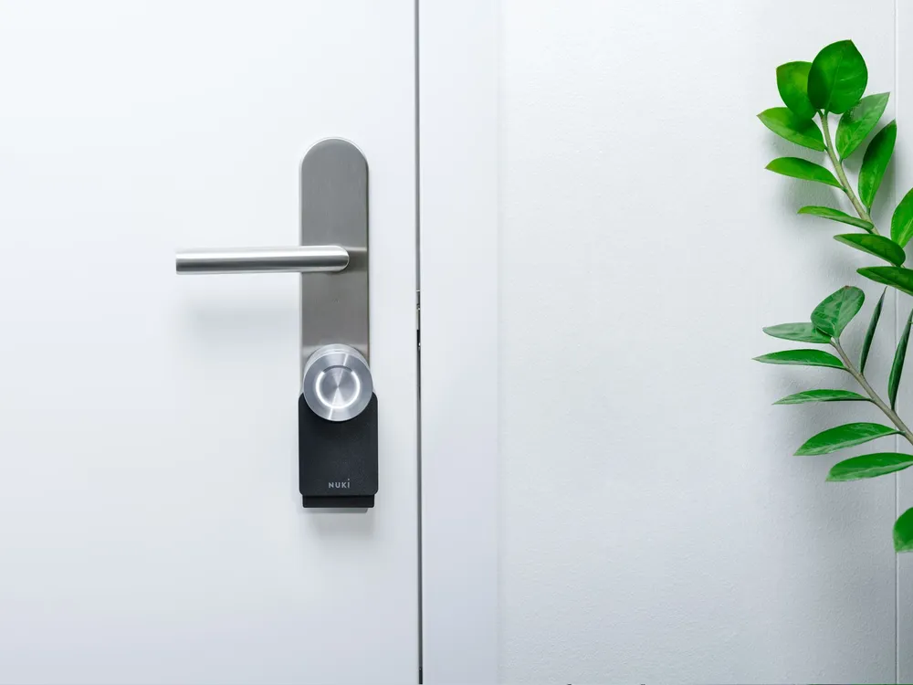 Dispositivo de Nuki en color negro instalado en la cerradura de la puerta